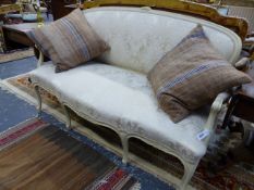 A CARVED AND PAINTED LOUIS XV STYLE SALON SETTEE WITH SHAPED UPHOLSTERED BACK AND SEAT ON CABRIOLE