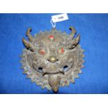 A TIBETAN BRONZE DRAGON MASK INSET WITH RED AND TURQUOISE CABOCHNS. W.26.5cms TOGETHER WITH