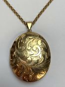 A 9ct GOLD SCROLL ENGRAVED LARGE OVAL HINGED LOCKET WITH A 9ct GOLD BELCHER NECKLACE, DATED 1979,