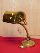 A BRASS TABLE LAMP, THE ARCHED RECTANGULAR SHADE RAISED ON AN ARM ROTATABLE UP AND DOWN ON A