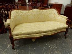 A 19th.C. ROSEWOOD SHOW FRAME SETTEE UPHOLSTERED IN YELLOW FLORAL DAMASK, THE FRONT LEGS CARVED WITH