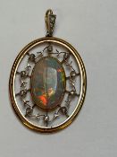 AN EDWARDIAN YELLOW METAL DIAMOND AND OPAL PENDANT, THE LARGE OVAL CUT CENTRAL OPAL IS IN A