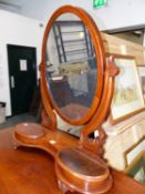 A 19th.C.MAHOGANY OVAL DRESSING TABLE MIRROR, THE FOLIATE CARVED SUPPORTS RESTING ON PLINTH WITH TWO