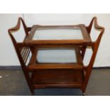 A ROSEWOOD THREE TIER TROLLEY, THE TWO UPPER RECTANGULAR TIERS GLAZED AND TAPERING DOWN FROM THE