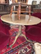 A MAHOGANY TRIPOD TABLE, THE CIRCULAR TOP TILTING ON A GUN BARREL COLUMN ON BRASS PAW TOPPED