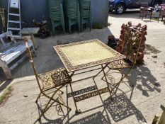 A PAINTED FOLDING PATIO TABLE WITH TWO MATCHING CHAIRS