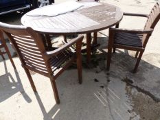 A CIRCULAR TEAK GARDEN TABLE WITH FOUR MATCHING ARM CHAIRS AND A PARASOL