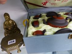 A POLISHED BRASS BUDDHA TOGETHER WITH A BOX OF YIXING TEA WARES.