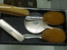 A HALLMARKED SILVER BACKED FIVE PIECE DRESSING TABLE SET.