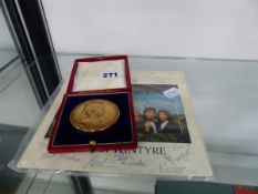 A BRONZE COMMEMORATIVE MEDAL AND A VINTAGE WINGS MULL OF KINTYRE SINGLE WITH VARIOUS INSCRIPTIONS.