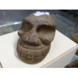 AN ARCHAIC STYLE CARVED STONE RITUAL SKULL.