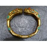 AN ARCHAIC STYLE TURQUOISE AND CORAL INSET DRAGON BANGLE.