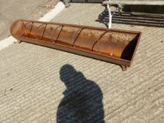 A LARGE CAST IRON FEEDING TROUGH TOGETHER WITH A CORNER TROUGH.