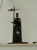 A LARGE WINE BOTTLE ON A RETORT STAND.