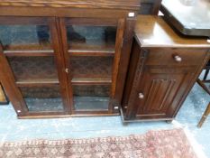 AN OAK BEDSIDE CABINET AND A GLAZED BOOKCASE.