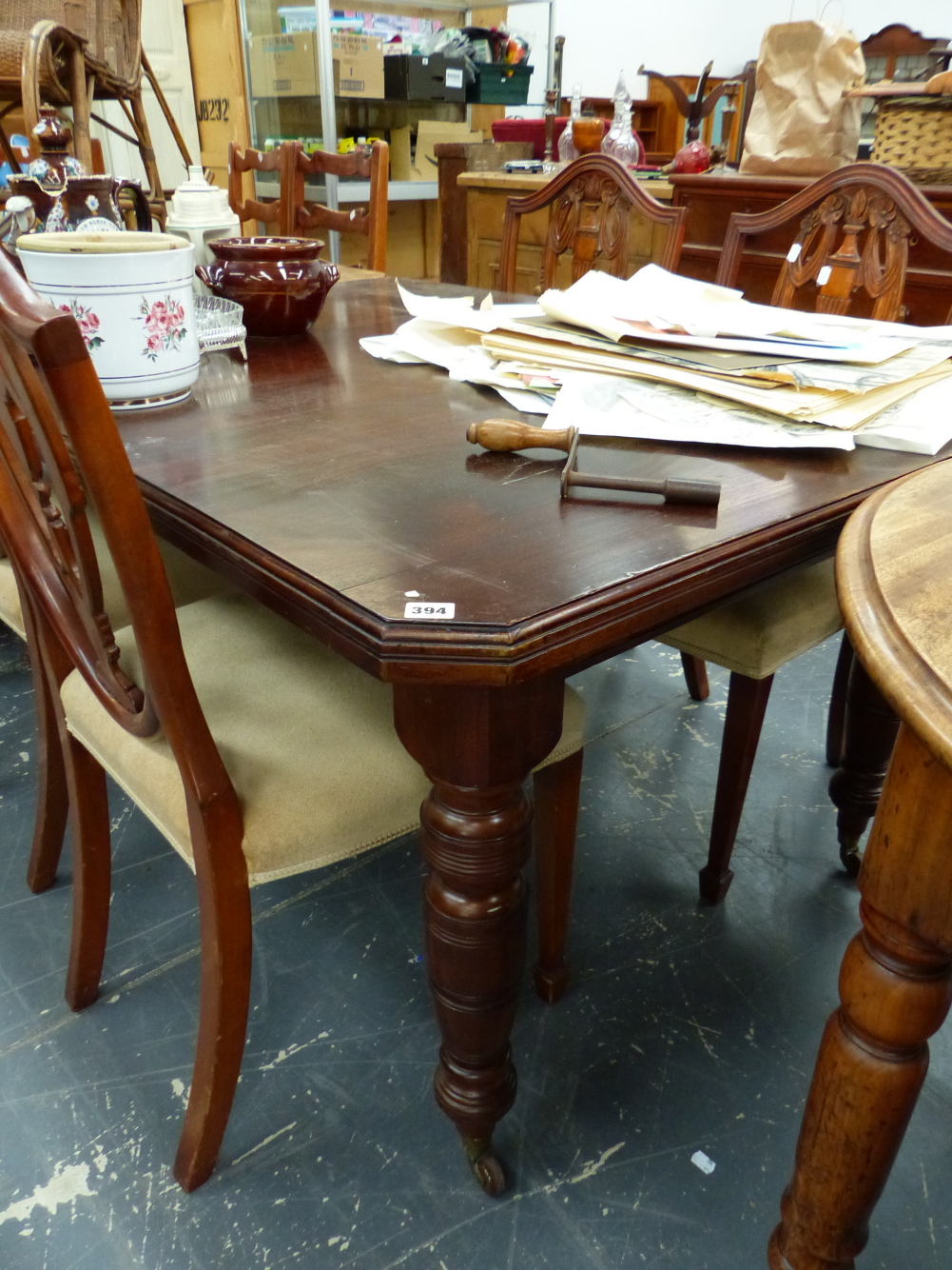 AN EDWARDIAN DINING TABLE WITH CANTED CORNERS.