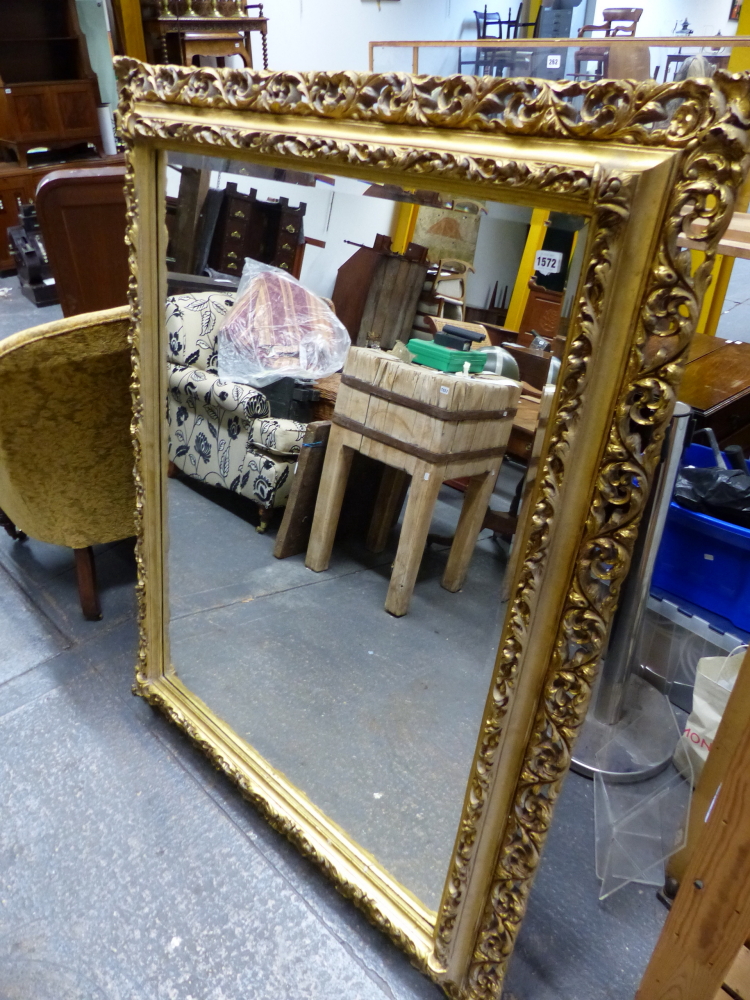 A BEVELLED GLASS RECTANGULAR MIRROR IN GILT GESSO PIERCED FOLIATE FRAME, OVERALL. 149 x 118cms.