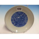 A CHINESE BLUE AND WHITE PLATE, THE EXTERIOR WITH DRAGONS AMONGST WAVES BELOW A CASH MEDALLION RIM