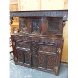 AN 18th.C.OAK COURT CUPBOARD WITH SINGLE UPPER CARVED PANEL DOOR OVER PAIR OF THREE PANEL DOORS TO