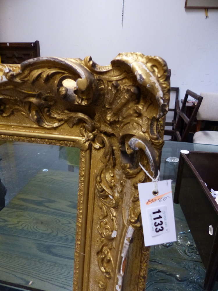 A LARGE VICTORIAN SWEPT GILT PICTURE FRAME IN THE FRENCH STYLE. REBATE 69 x 99.5cms.
