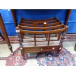 A MAHOGANY FIVE RACK CANTERBURY, A DRAWER ABOVE THE BALUSTER TURNED LEGS WITH BRASS CASTER FEET. W