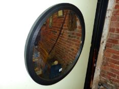 AFTER SIR JOHN SOANE, A CONVEX MIRROR WITHIN REEDED CIRCULAR EBONISED FRAME. Dia. 65.5cms.
