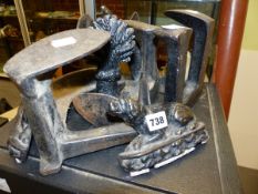 A PAIR OF IRON RECLINING DOG DOOR STOPS. W 15.5cms A LEAD WHEATSHEAF DOORSTOP. H 17cms TOGETHER WITH