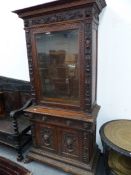 A 19th.C.CARVED OAK BOOKCASE WITH GLAZED UPPER SECTION OVER FRIEZE DRAWER AND CABINET DOORS. 97 x 50