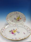 TWO MEISSEN OVAL PLATTERS PAINTED WITH FLOWERS WITHIN WAVY GILT LINED RIMS. W 34 and 40cms