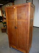 A HEALS OAK TWO DOOR WARDROBE WITH EBONISED BLOCK HANDLES AND PANEL SIDES AND DOORS. 91 x 52 x H.