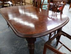 A SMALL LATE VICTORIAN MAHOGANY WIND OUT DINING TABLE ON TURNED FLUTED LEGS WITH BRASS CASTERS. W.