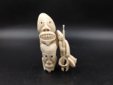 AN INUIT MARINE IVORY FIGURE OF A HUNTER WITH HARPOON. H 10cms. TOGETHER WITH A GROTESQUE FIGURE