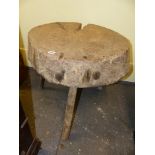 AN ANTIQUE RUSTIC CHOPPING BLOCK ON THREE NATURAL STICK LEGS. 68 x 60 x H.62cms.