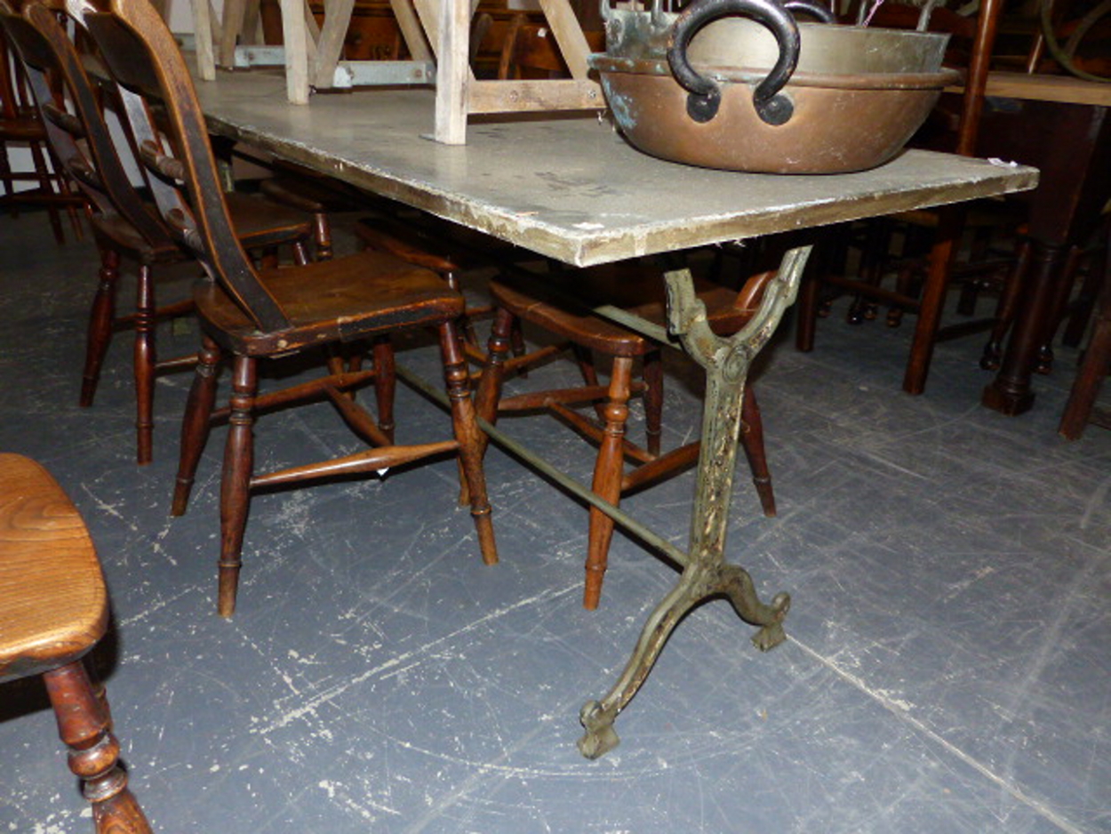 A SET OF THREE CAST IRON BASED TABLES WITH CAST IRON TRESTLE BASES AND ZINC WRAPPED TOPS. 69 x 210 x