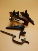 A BAG OF TWO PERCUSSION MUSKET LOCKS AND A BRASS TRIGGER GUARD TOGETHER WITH A REPRO BRASS FLINTLOCK