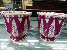 A PAIR OF POTTERY CACHE POTS, THE PURPLE GROUND EXTERIORS WITH FERN AND OTHER LEAVES LEFT IN THE