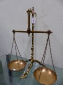 A SET OF DOYLE AND SONS, LONDON BRASS BALANCE SCALES, THE PANS RAISED ON THE TRIPOD STAND BY A