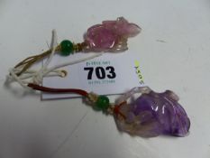 TWO CHINESE AMETHYST PENDANTS, ONE CARVED AS A FRUIT. H 5cms. THE OTHER AS A FISH. H 5.5cms