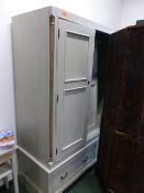 A MODERN PAINTED PINE TRIPLE DOOR WARDROBE WITH A TWO DRAWER BASE AND SHAPED BRACKET FEET. 165 x