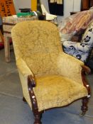 A LATE GEORGIAN MAHOGANY FRAME LIBRARY ARMCHAIR ON TURNED FORELEGS WITH BRASS CASTERS.