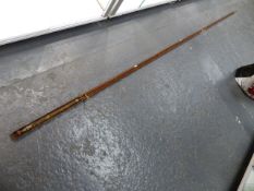 AN ANTIQUE HARDY'S SINGLE PIECE FISHING ROD IN PERIOD WOODEN PROTECTIVE SHEATH. THE ROD L.336cms.