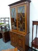 AN EDWARDIAN MAHOGANY AND INLAID BOOKCASE WITH TWIN ASTRAGAL GLAZED UPPER DOORS OVER PANEL DOORS, ON