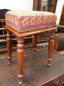 A VICTORIAN MAHOGANY STOOL WITH NEEDLEPOINT SEAT OVER SLIGHTLY SPLAYED TURNED LEGS. 36 x 26 x H.