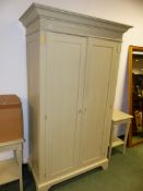 A MODERN TWO DOOR PAINTED WARDROBE ON BRACKET FEET. 122 x 65 x H.205cms.