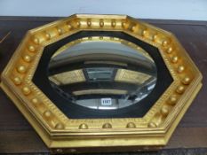 AN ANTIQUE AND LATER OCTAGONAL GILT FRAMED WALL MIRROR WITH BALL DECORATION AND TWIN CANDLE ARMS. 69