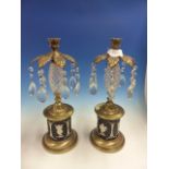 A PAIR OF LUSTRE CANDLESTICKS WITH DIAMOND HATCHED GLASS SPINDLE COLUMNS, FOLIATE SOCLES ABOVE BLACK