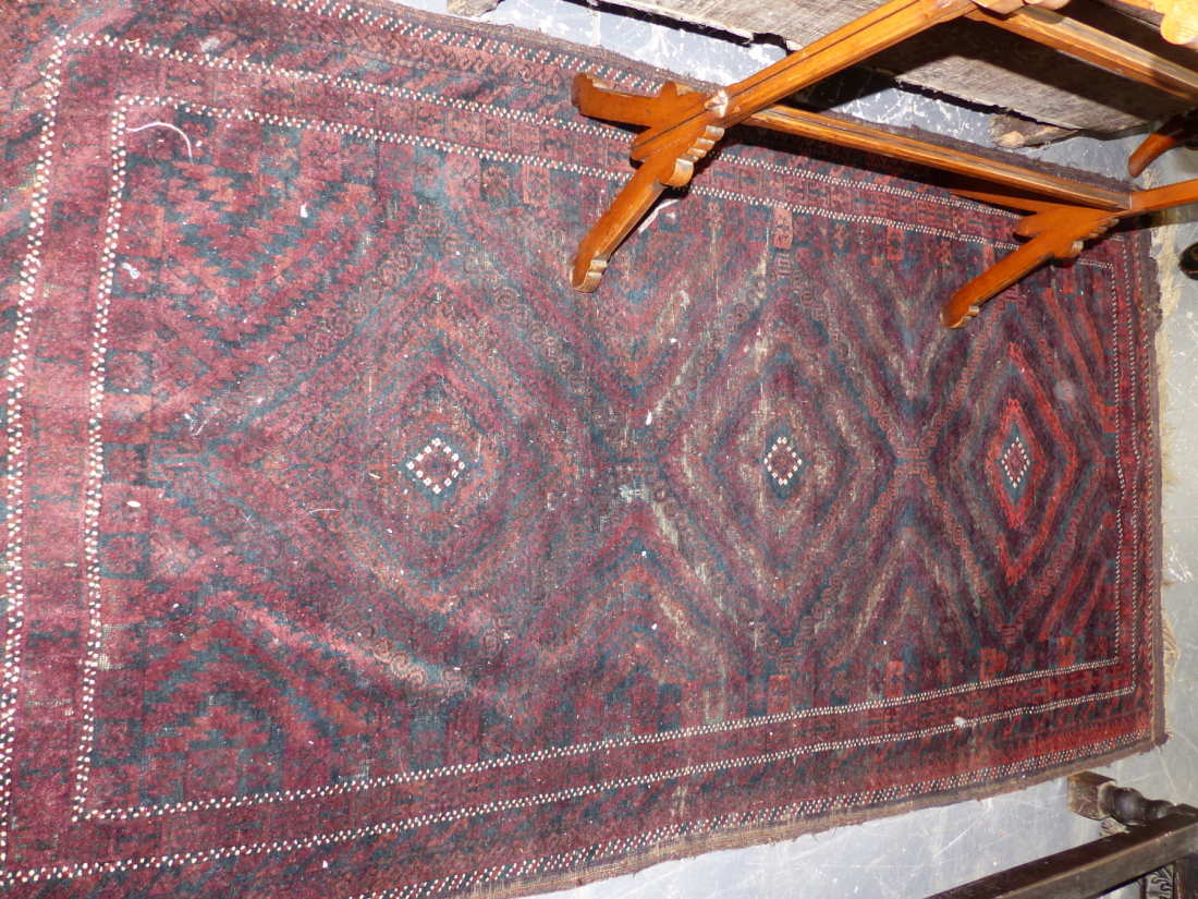 AN ANTIQUE BELOUCH RUG. 225 x 114cms TOGETHER WITH THREE TRIBAL BELOUCH PRAYER RUGS. (4)