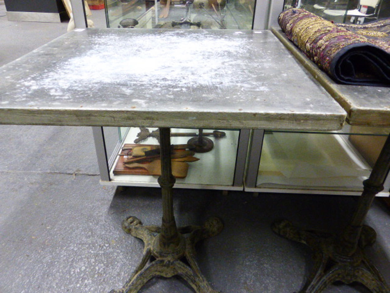 A PAIR OF VINTAGE CAFE TABLES WITH CAST IRON BASES AND ZINC WRAPPED PINE TOPS. 59 x 59 x H.73cms. - Image 7 of 8