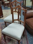 A SET OF FOUR VICTORIAN GOTHIC REVIVAL OAK SIDE CHAIRS WITH OVERSTUFFED SEATS. (4)