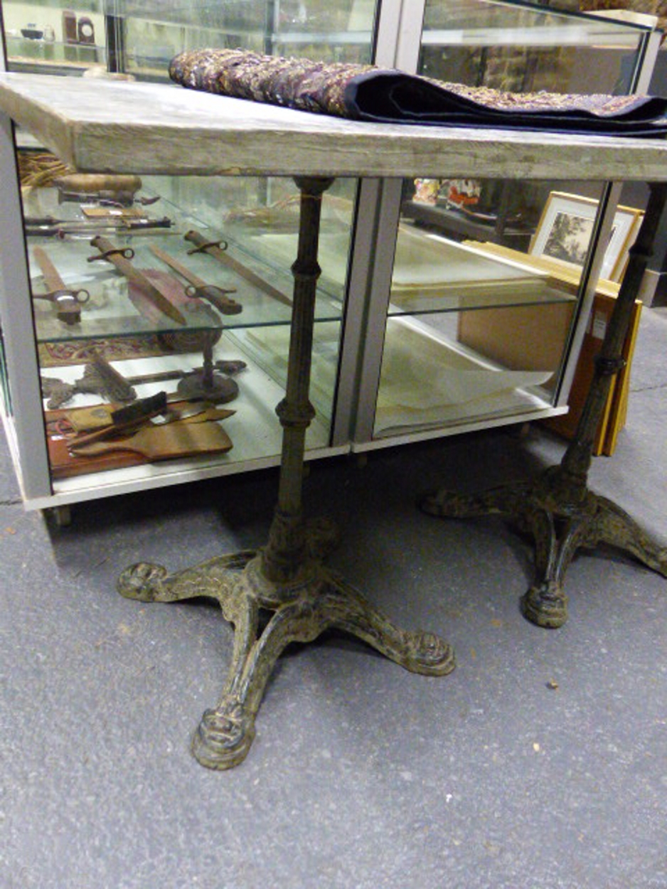 A PAIR OF VINTAGE CAFE TABLES WITH CAST IRON BASES AND ZINC WRAPPED PINE TOPS. 59 x 59 x H.73cms. - Image 3 of 8